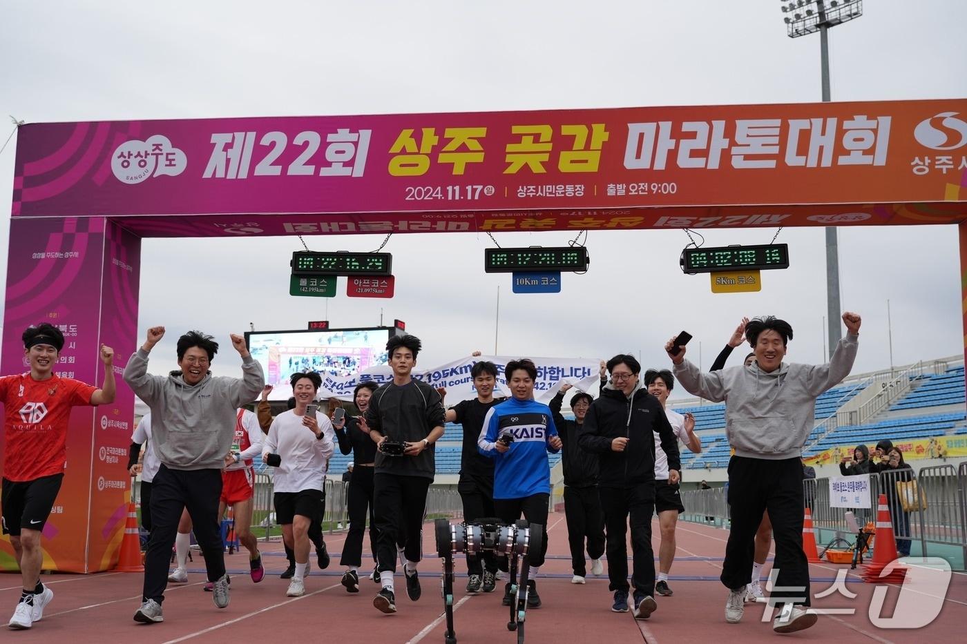 본문 이미지 - 상주 곶감 마라톤을 완주하고 결승선을 통과하는 KAIST 사족보행로봇 '라이보2'와 연구진(KAIST 제공) /뉴스1