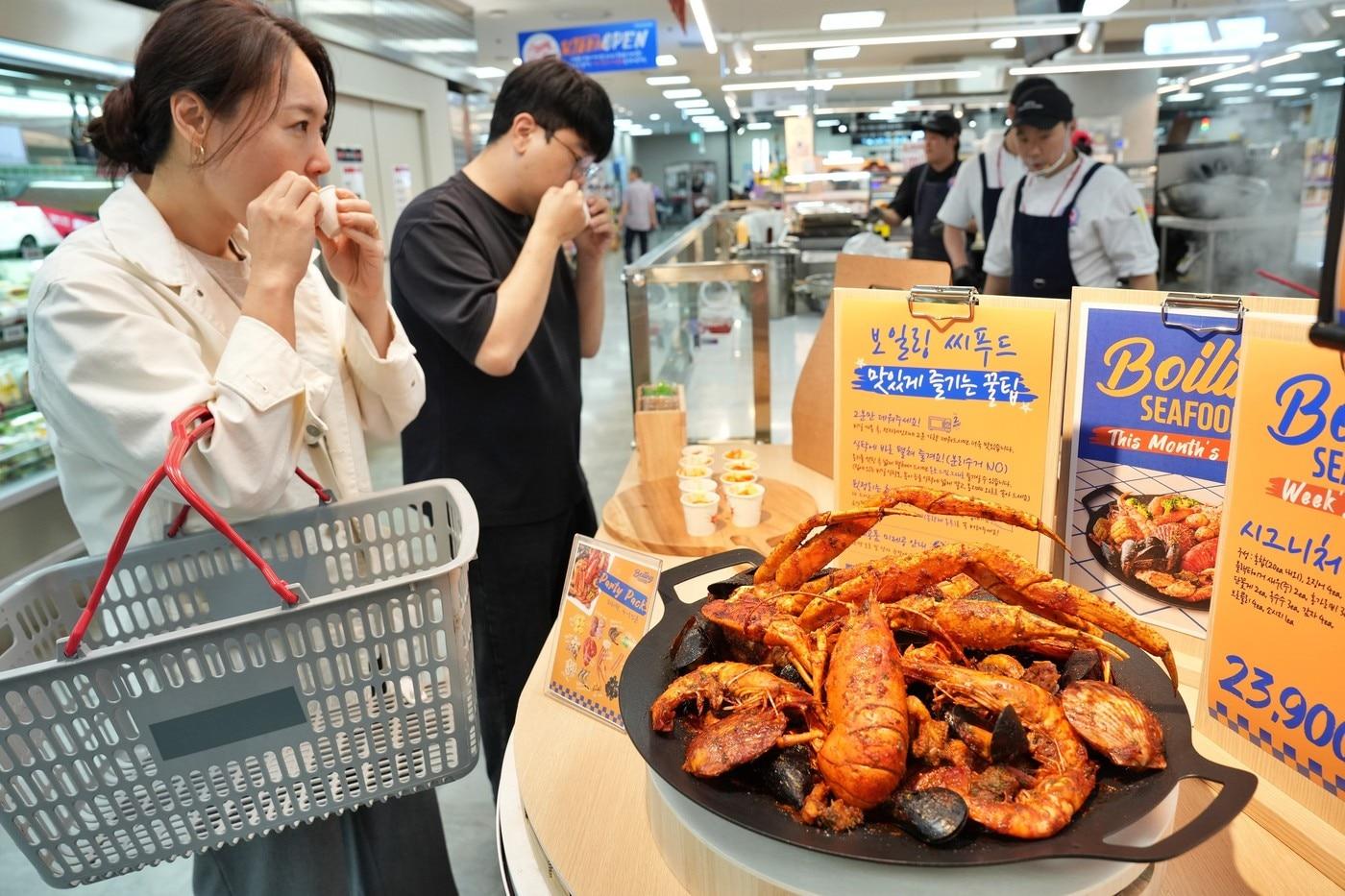 본문 이미지 - 서울시 송파구에 위치한 롯데마트 제타플렉스 잠실점 '파일럿 키친'에서 '보일링 씨푸드'를 시식하고 있는 모습.(롯데마트 제공)