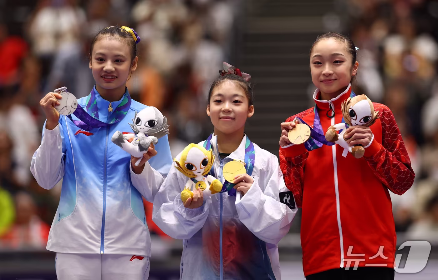 본문 이미지 - 대한민국 기계체조 황서현 선수(가운데)가 25일 일본 나고야시 종합체육관에서 열린 2026 아이치·나고야 아시안게임 기계체조 여자 평행봉 개인전 시상식에서 금메달을 들고 수상자들과 기념촬영을 하고 있다. ⓒ 로이터=뉴스1