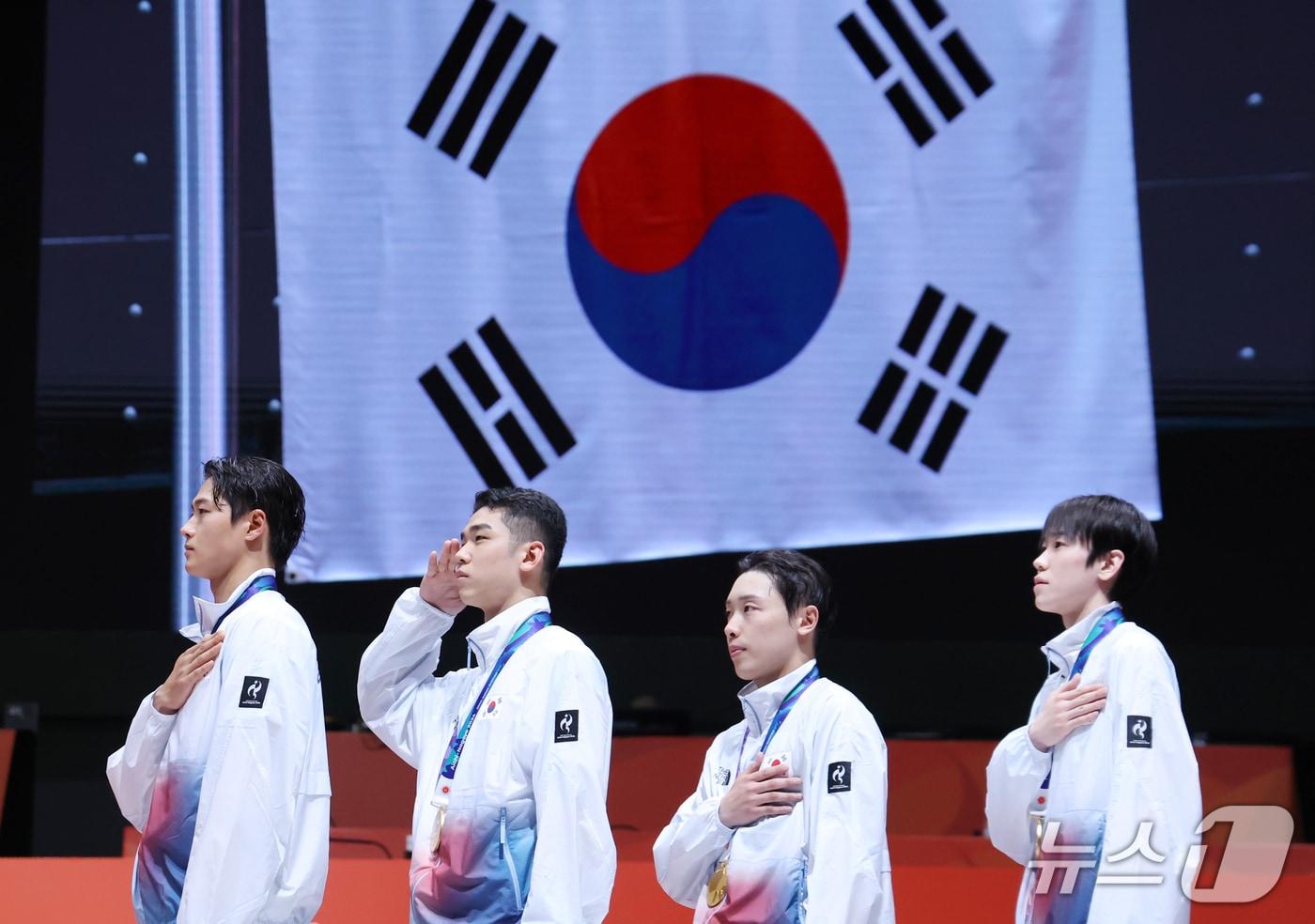 본문 이미지 - 26일 일본 아이치현 도코나메 아이치 스카이 엑스포에서 열린 2026 아이치·나고야 아시안게임 펜싱 남자 사브르 단체전 결승에서 역전 드라마를 쓰며 아시안게임 4연패를 달성한 오상욱, 박상원, 도경동, 황희근이 시상대에 올라 국민의례를 하고 있다. 2026.9.26 ⓒ 뉴스1 김민지 기자