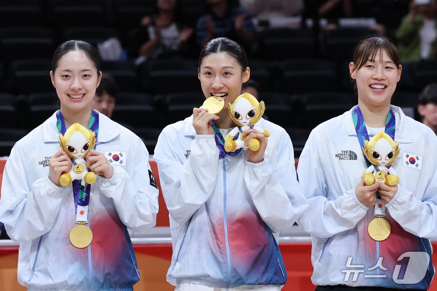 본문 이미지 - 대한민국 이해란(가운데)이 26일 일본 나고야 아이치 인터내셔널 아레나에서 열린 2026 아이치·나고야 아시안게임 여자농구 시상식에서 금메달을 깨물고 있다. 2026.9.26 ⓒ 뉴스1 안은나 기자