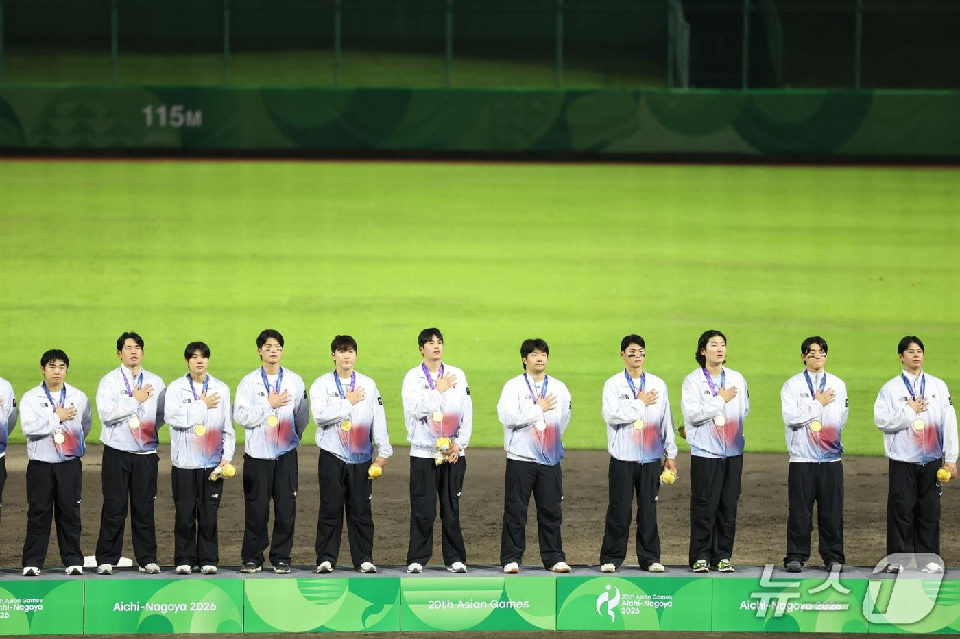 본문 이미지 - 대한민국 야구 국가대표팀 선수들이 지난 27일 일본 아이치현 도요하시 시민구장에서 열린 2026 아이치·나고야 아시안게임 야구 시상식에서 금메달을 목에 걸고 국기에 대한 경례를 하고 있다. 2026.9.27 ⓒ 뉴스1 김도우 기자