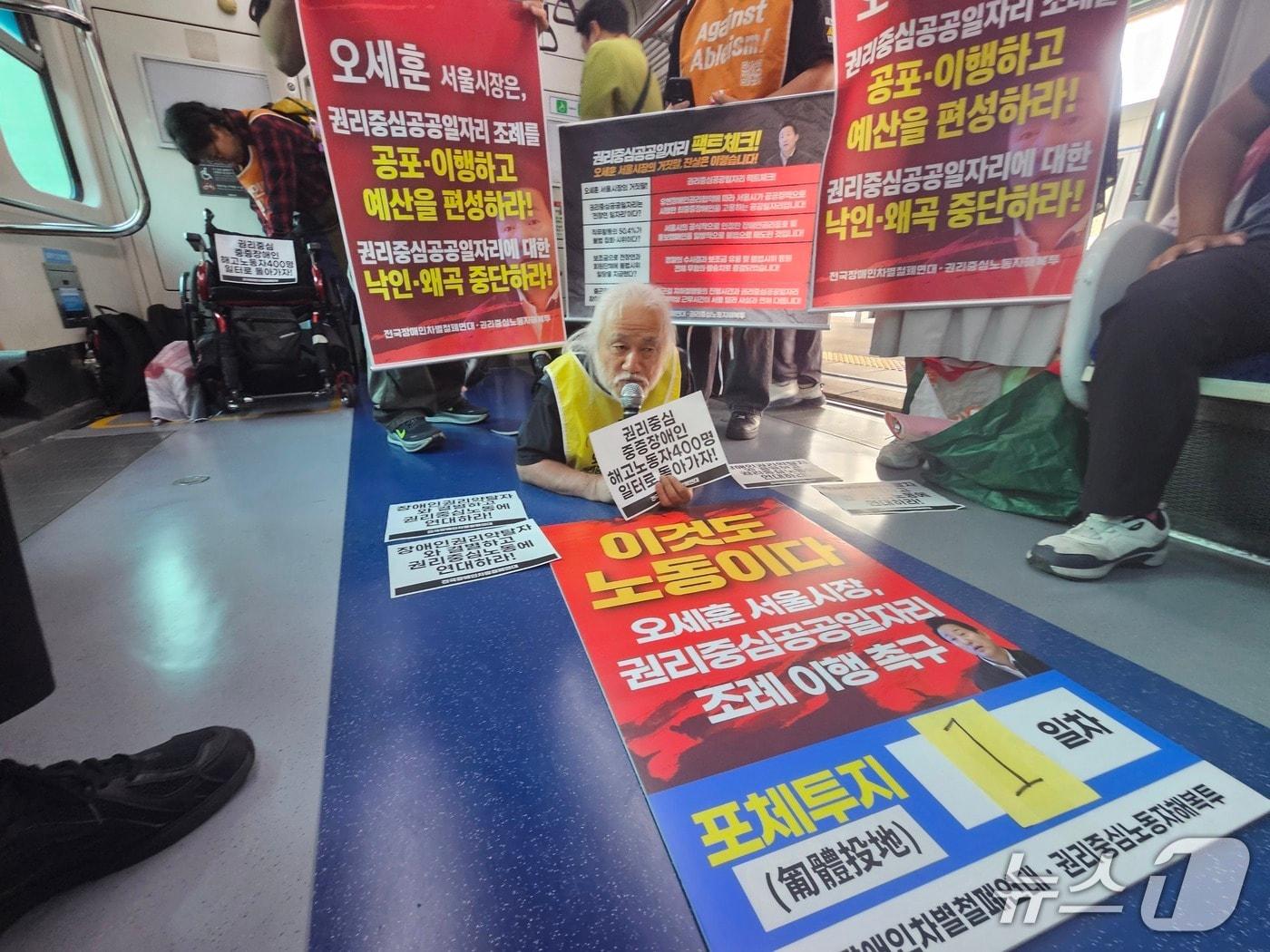 본문 이미지 - 전국장애인차별철폐연대(전장연)가 28일 권리중심공공일자리 관련 조례 이행을 요구하며 출근길 지하철에서 몸을 낮춰 기어가는 방식의 '포체투지'에 나섰다. 2026.9.28. ⓒ 뉴스1 윤지오 기자