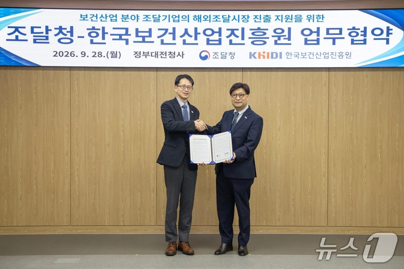 본문 이미지 - 백승보 조달청장(왼쪽)과 고상백 한국보건산업진흥원장이 28일 정부대전청사에서 '보건산업 분야 기업의 해외조달시장 진출 지원을 위한 업무협약'을 맺고 악수를 하고 있다. (조달청 제공. 재판매 및 DB금지) /뉴스1