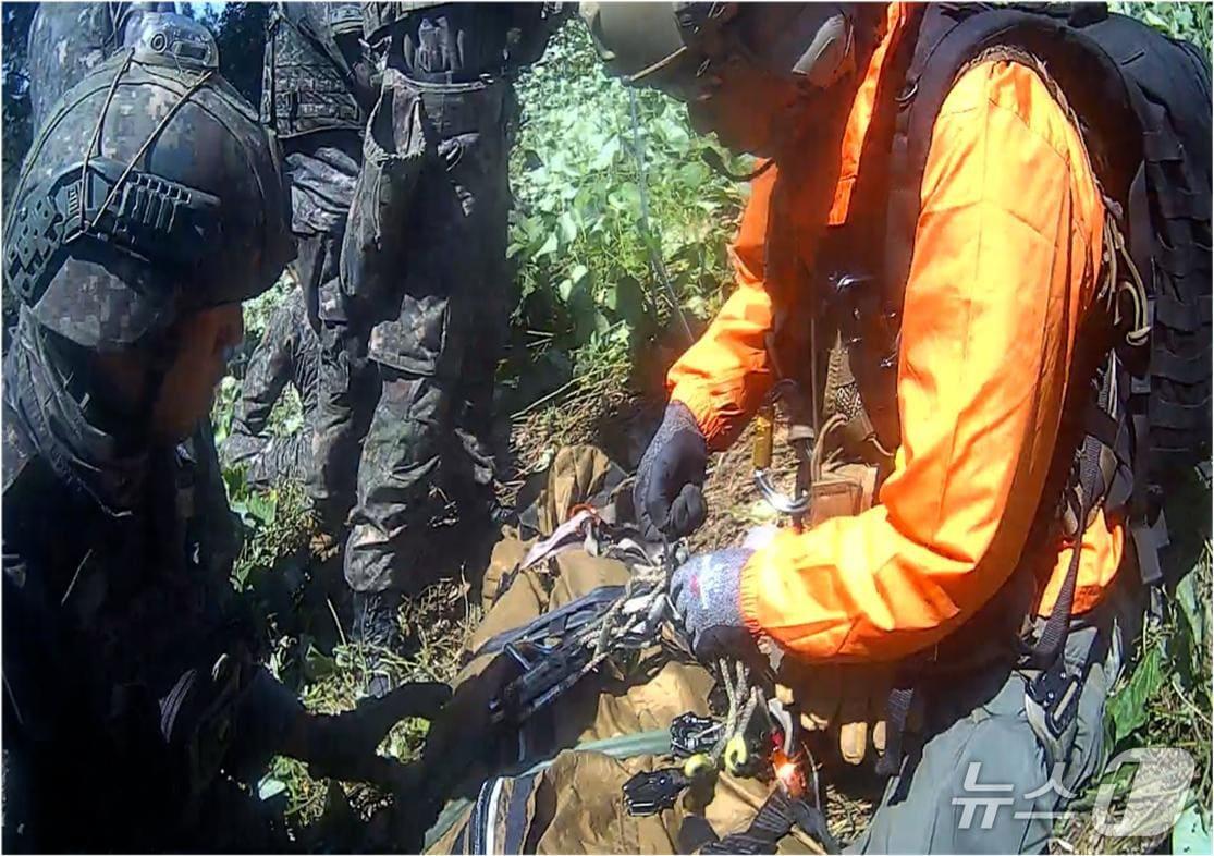 본문 이미지 - 28일 서울 용산구 국방부에서 열린 DMZ 지뢰 추정 폭발 사고 브리핑에서 공개된 폭발 사고 이후 응급구조사의 부상자 이송 당시 사진. (합동참모본부 제공. 재판매 및 DB 금지) 2026.9.28 ⓒ 뉴스1