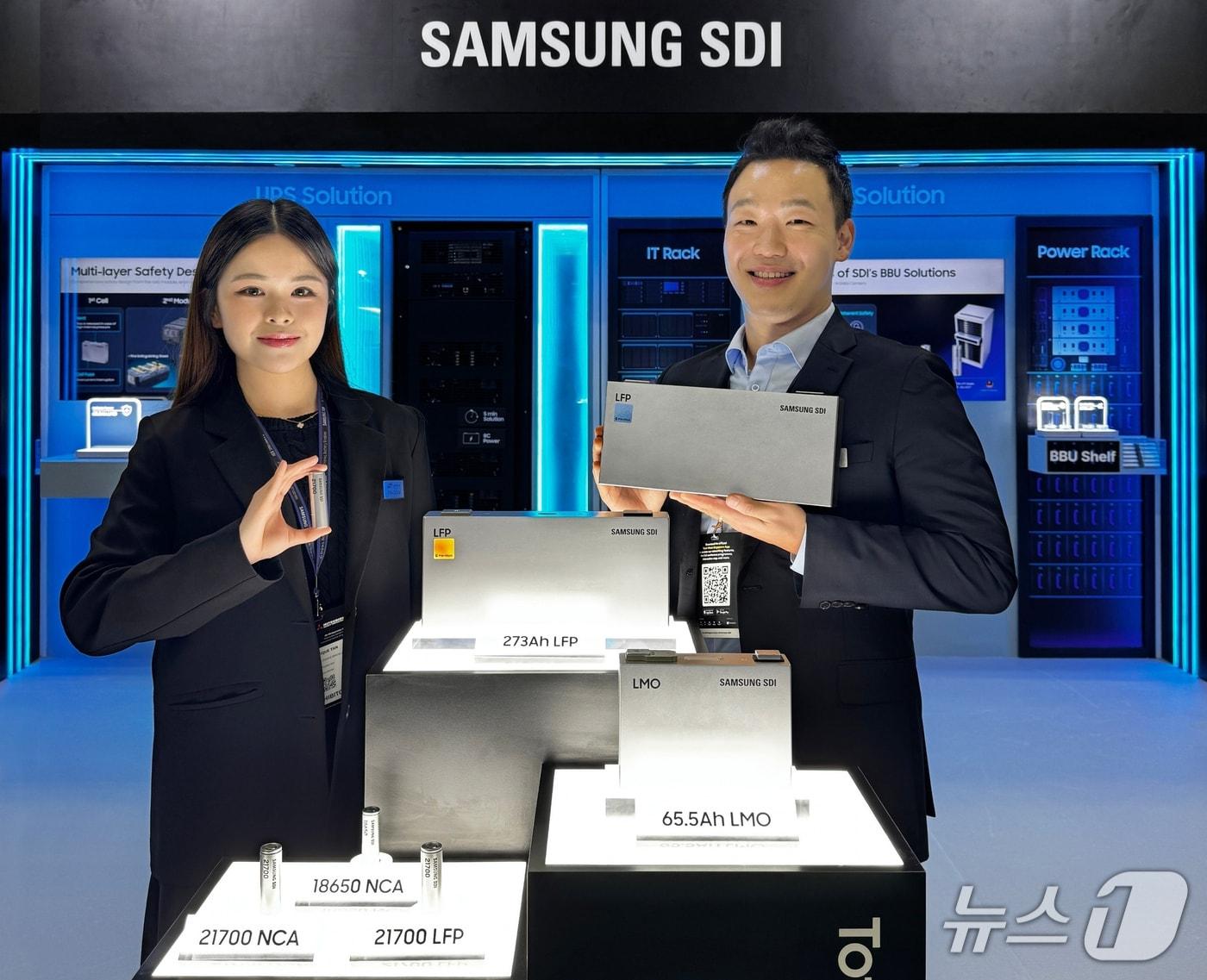 본문 이미지 - 삼성SDI 임직원 모델들이 29일 싱가포르에서 개막한 아시아 최대 데이터센터 전시회 '데이터센터 월드 아시아(DCWA) 2026'에서 데이터센터용 원통형 리튬인산철(LFP) 배터리(왼쪽)와 각형 LFP 배터리(오른쪽)를 소개하고 있다. (삼성SDI 제공)