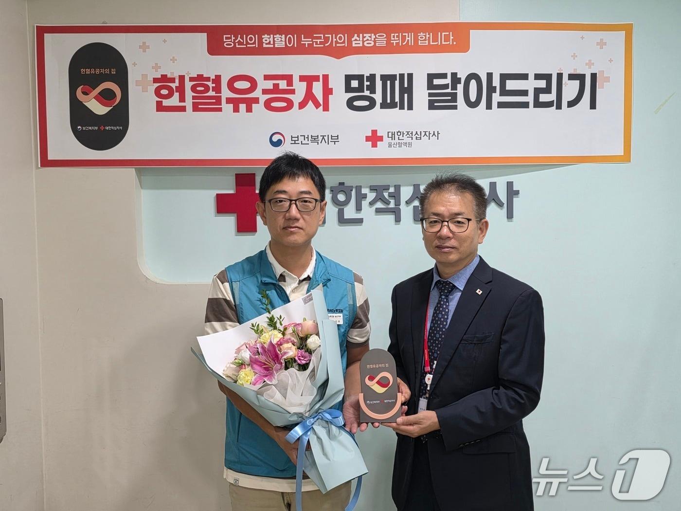 본문 이미지 - 정진우 씨(왼쪽)가 29일 헌혈의집 성남동센터에서 헌혈 유공자의 집 명패를 받았다.(대한적십자사 울산혈액원 제공. 재판매 및 DB 금지)/뉴스1