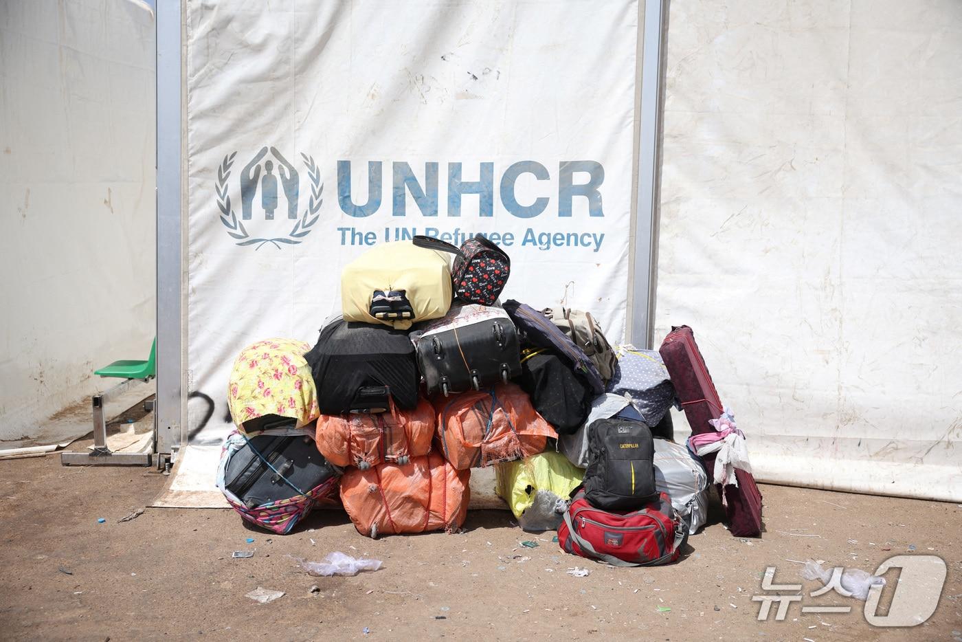 본문 이미지 - 2025년 7월 22일 아프가니스탄의 한 국경검문소 인근 유엔난민기구(UNHCR) 천막 옆에 이란에서 추방된 아프가니스탄 주민들의 짐이 놓여 있다. 2025.7.22 ⓒ 로이터=뉴스1