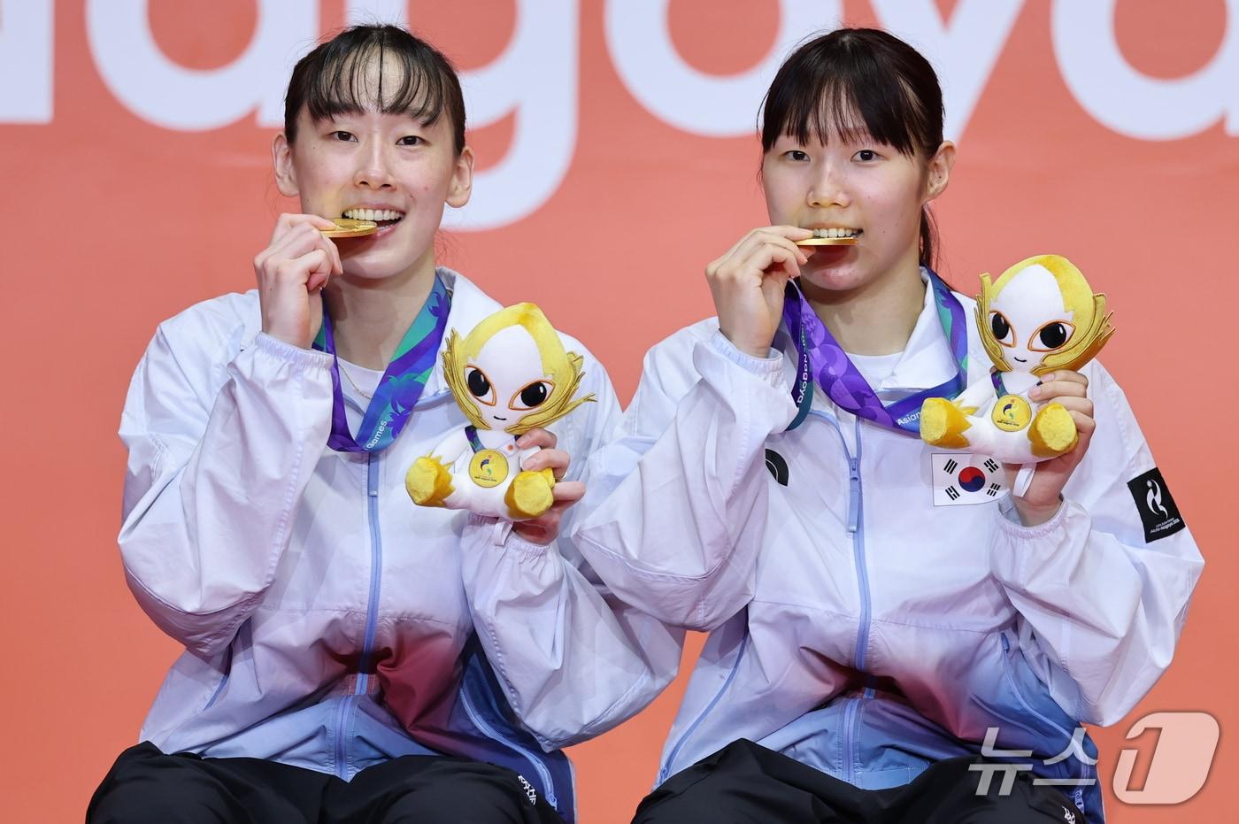 본문 이미지 - 대한민국 이소희, 백하나가 29일 일본 이치노미야 시립체육관에서 열린 2026 아이치·나고야 아시안게임 배드민턴 여자 복식 시상식에서 금메달을 깨물고 기념촬영을 하고 있다. 2026.9.29 ⓒ 뉴스1 김도우 기자