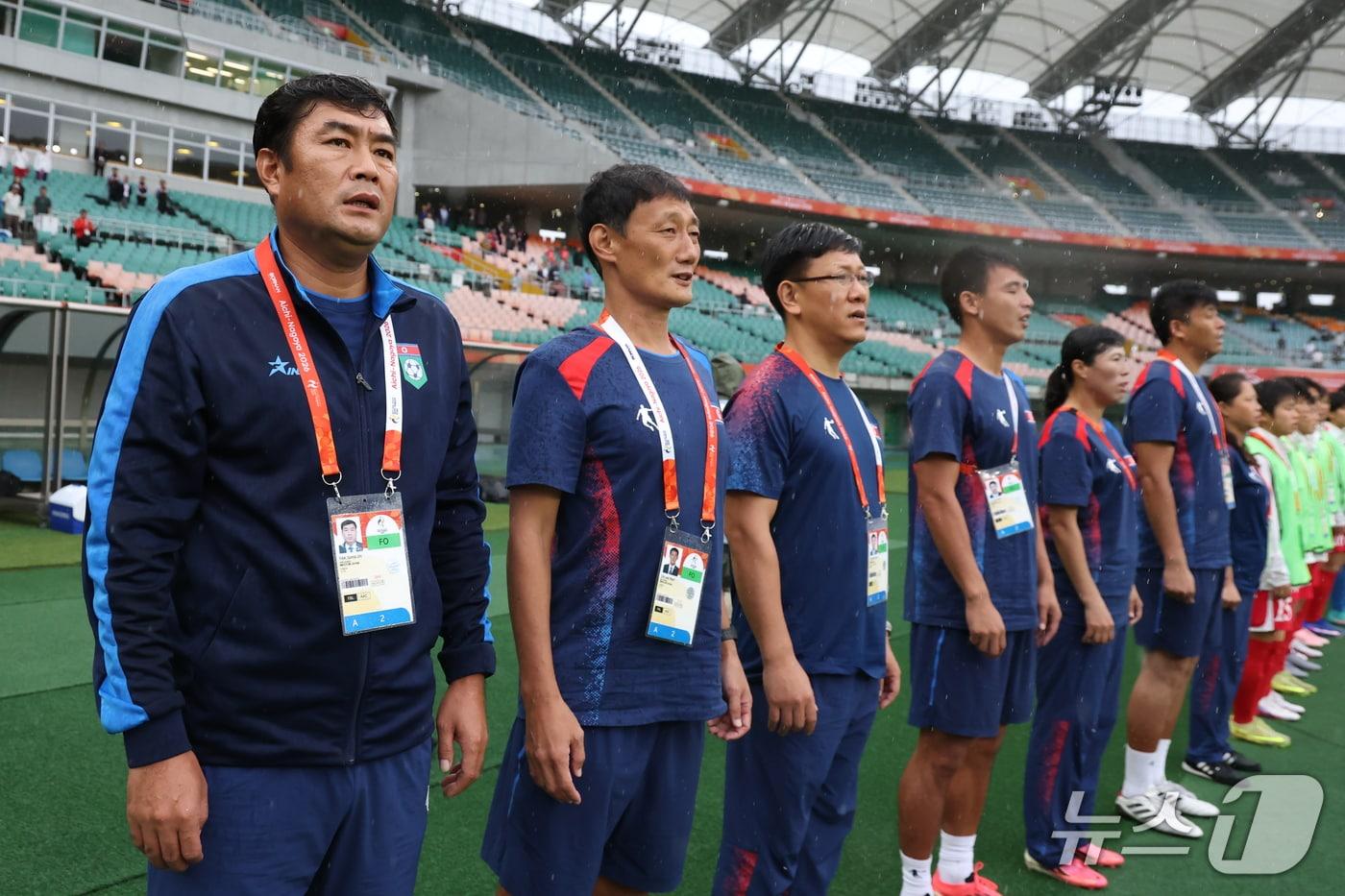 본문 이미지 - 29일 오후 일본 시즈오카 스타디움 에코파에서 열린 2026 아이치·나고야 아시안게임 여자축구 4강전 북한과 중국의 경기, 북한 박성진 감독 및 스태프들이 국가를 부르고 있다. 2026.9.29 ⓒ 뉴스1 김민지 기자