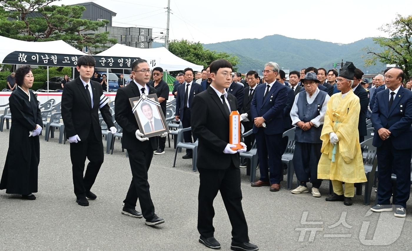본문 이미지 - 3일 오전 고령군청에서 열린 故 이남철 경북 고령군수 영결식에서 이 군수의 유족들이 영정사진을 들고 군청으로 향하고 있다. '고령군장(郡葬)'으로 엄수된 영결식에는 1000여명의 군민이 참석해 고인의 마지막 길을 배웅했다. 2026.9.3(고령군 제공. 재판매 및 DB금지) ⓒ 뉴스1 정우용 기자