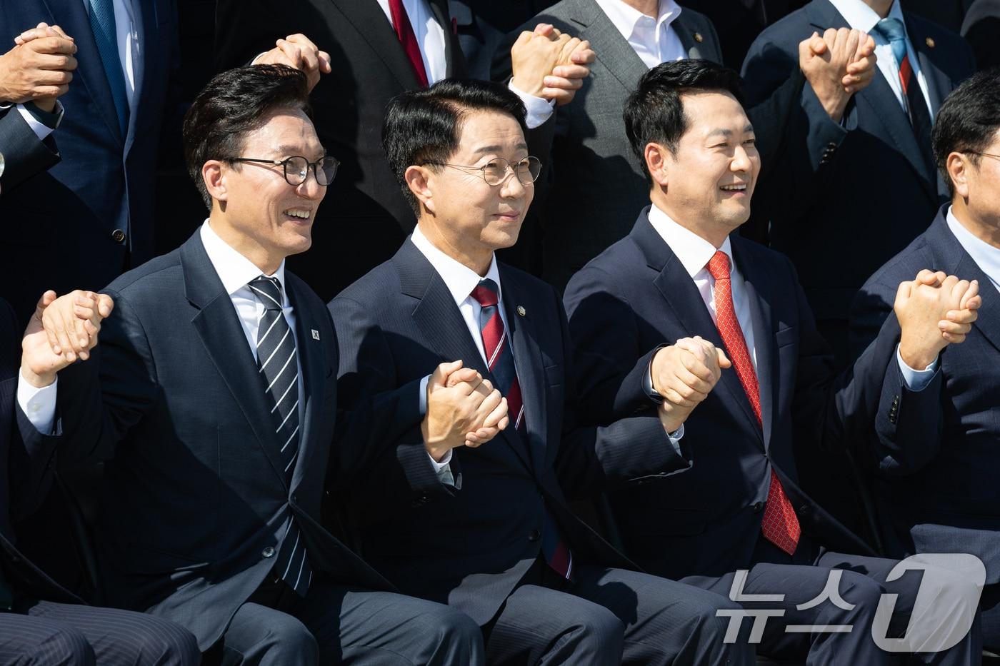 본문 이미지 - 조정식 국회의장과 더불어민주당 김민석, 국민의힘 장동혁 대표가 3일 서울 여의도 국회에서 제22대 국회 후반기 국회의원 단체사진 촬영 중 손을 맞잡고 있다. 2026.9.3 ⓒ 뉴스1 유승관 기자