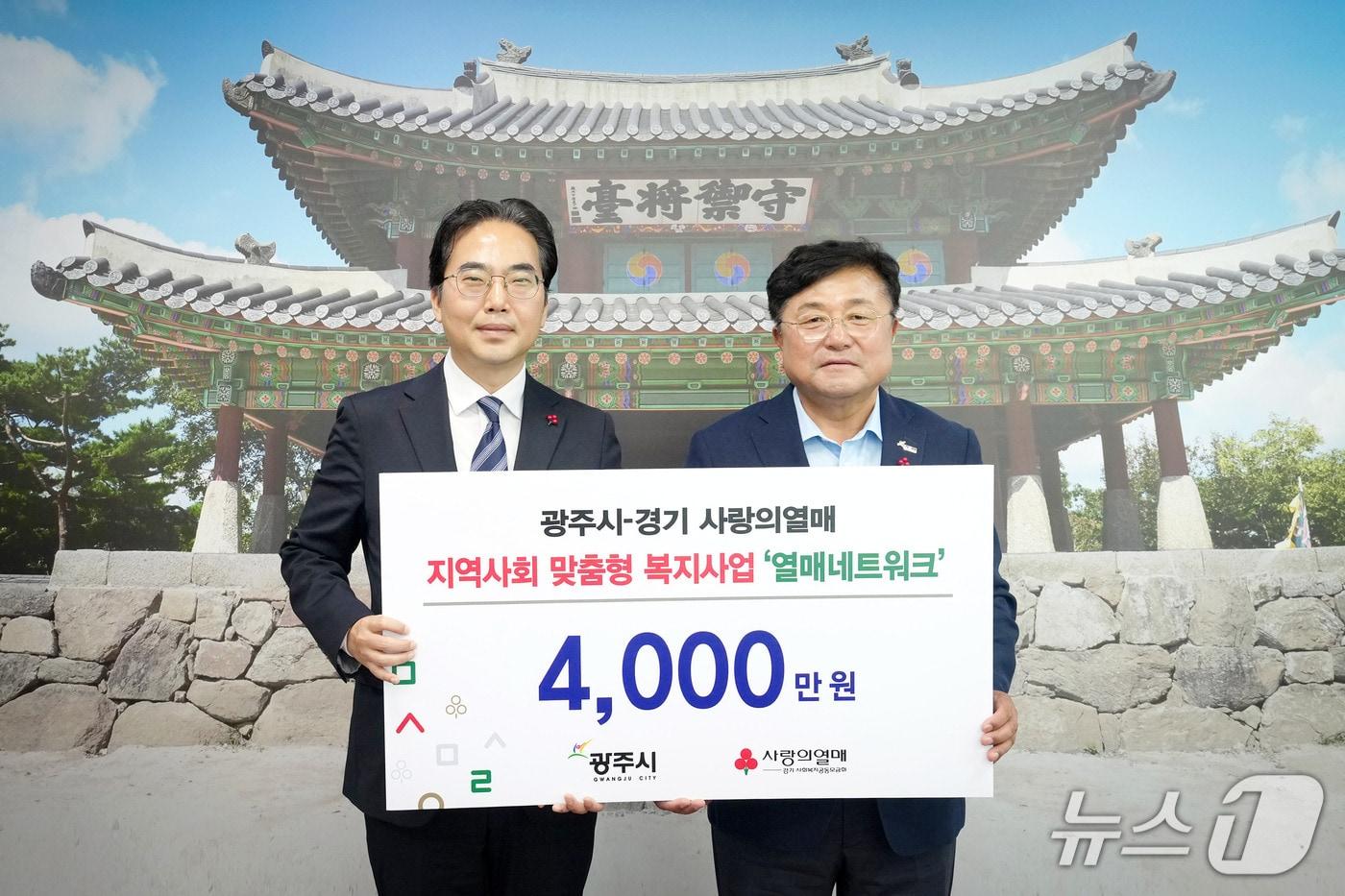 본문 이미지 - 김효진 경기 사랑의열매 사무처장(왼쪽)이 박관열 광주시장에게 '열매 네트워크' 사업비를 전달하고 있는 모습.(광주시 제공)