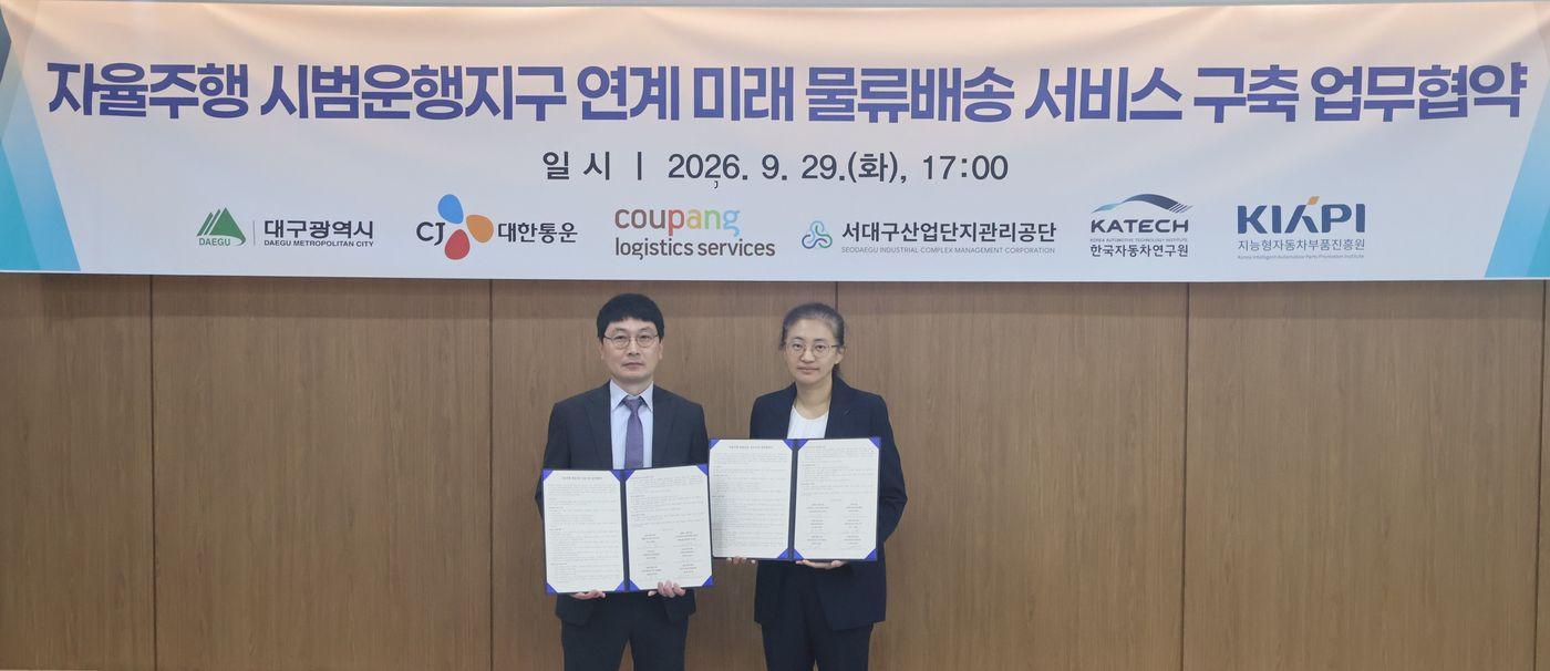 본문 이미지 - CLS 오상원 상무(왼쪽)와 대구광역시 김신영 미래모빌리티과장(오른쪽)이 29일 대구 자율주행 화물운송 실증사업 업무협약(MOU) 체결식에서 기념촬영을 하고 있다.(쿠팡 제공)