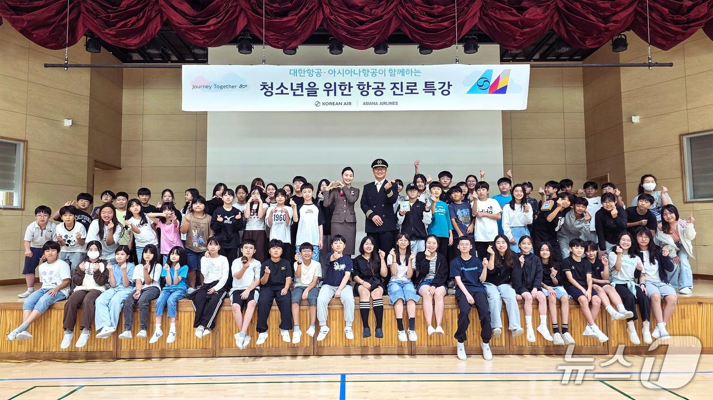 본문 이미지 - 대한항공·아시아나항공 교육기부 봉사단은 지난 29일 오후 경기도 고양시 장촌초등학교에서 5·6학년 학생 60여 명을 대상으로 항공 진로 특강을 진행했다. 사진은 항공 진로 특강에 참가한 학생들이 대한항공 운항승무원, 아시아나항공 객실승무원 멘토와 기념사진을 촬영하는 모습.(대한항공 제공)