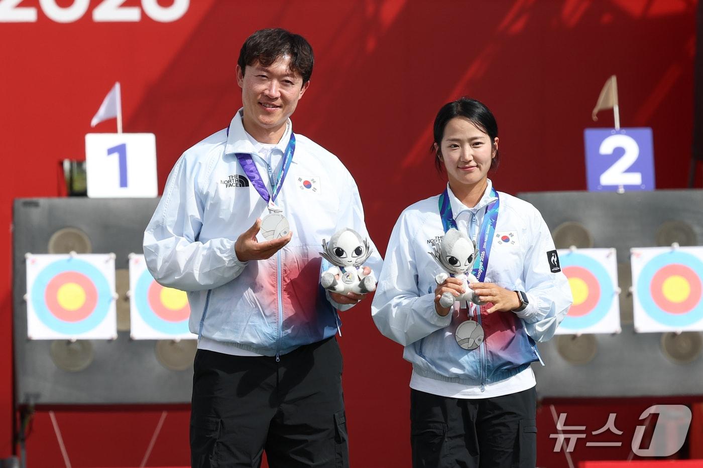 본문 이미지 - 대한민국 최용희, 박정윤이 30일 일본 오카자키 중앙종합공원 다목적광장에서 열린 2026 아이치·나고야 아시안게임 양궁 컴파운드 혼성 단체전 시상식에서 은메달을 목에 걸고 있다. 2026.9.30 ⓒ 뉴스1 안은나 기자