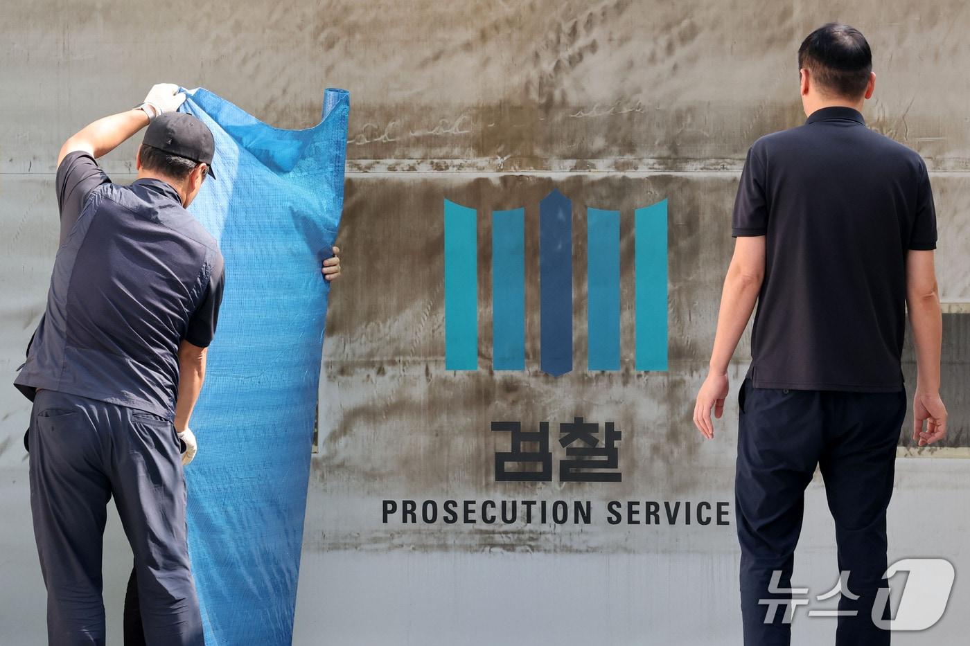 본문 이미지 - 공소청·중대범죄수사청 출범을 이틀 앞둔 30일 서울 서초구 대검찰청에서 관계자들이 주차장 출입문에 새겨진 검찰 표식을 가리기 위한 준비작업을 하고 있다. 2026.9.30 ⓒ 뉴스1 이광호 기자