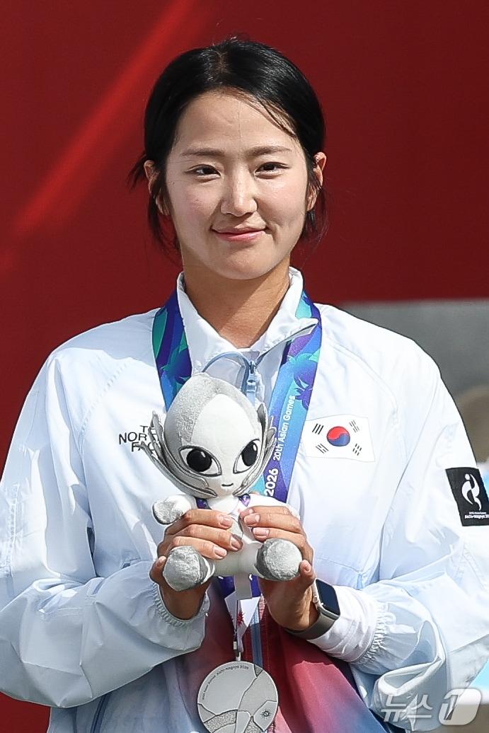 본문 이미지 - 대한민국 박정윤이 30일 일본 오카자키 중앙종합공원 다목적광장에서 열린 2026 아이치·나고야 아시안게임 양궁 컴파운드 혼성 단체전 시상식에서 은메달을 목에 걸고 있다. 2026.9.30 ⓒ 뉴스1 안은나 기자