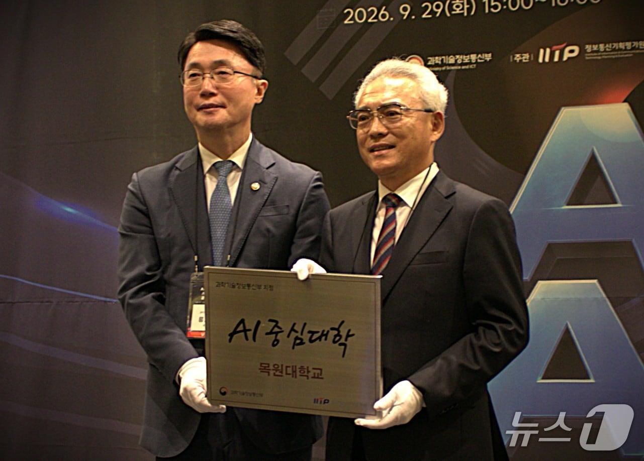 본문 이미지 - 'AI중심대학·AX대학원 공동 출범식'에서 이희학 총장(오른쪽)이 류제명 과학기술정보통신부 2차관으로부터 'AI중심대학 선정 현판'을 전달받으며 기념촬영을 하고 있다. (목원대학교 제공. 재판매 및 DB금지) /뉴스1