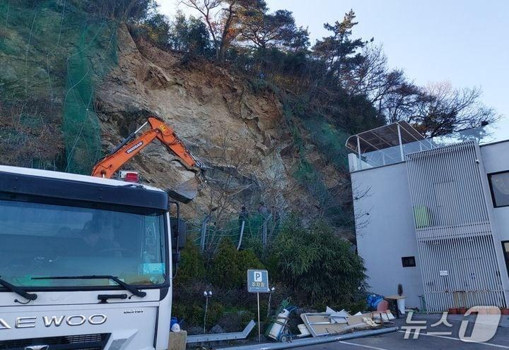 본문 이미지 - 지난 2024년 2월 16일 전남광주 북구 월출동 한 야산 경사면에서 돌덩이가 쏟아져 인근 카페 벽면이 무너지는 사고가 발생한 모습.뉴스1 DB