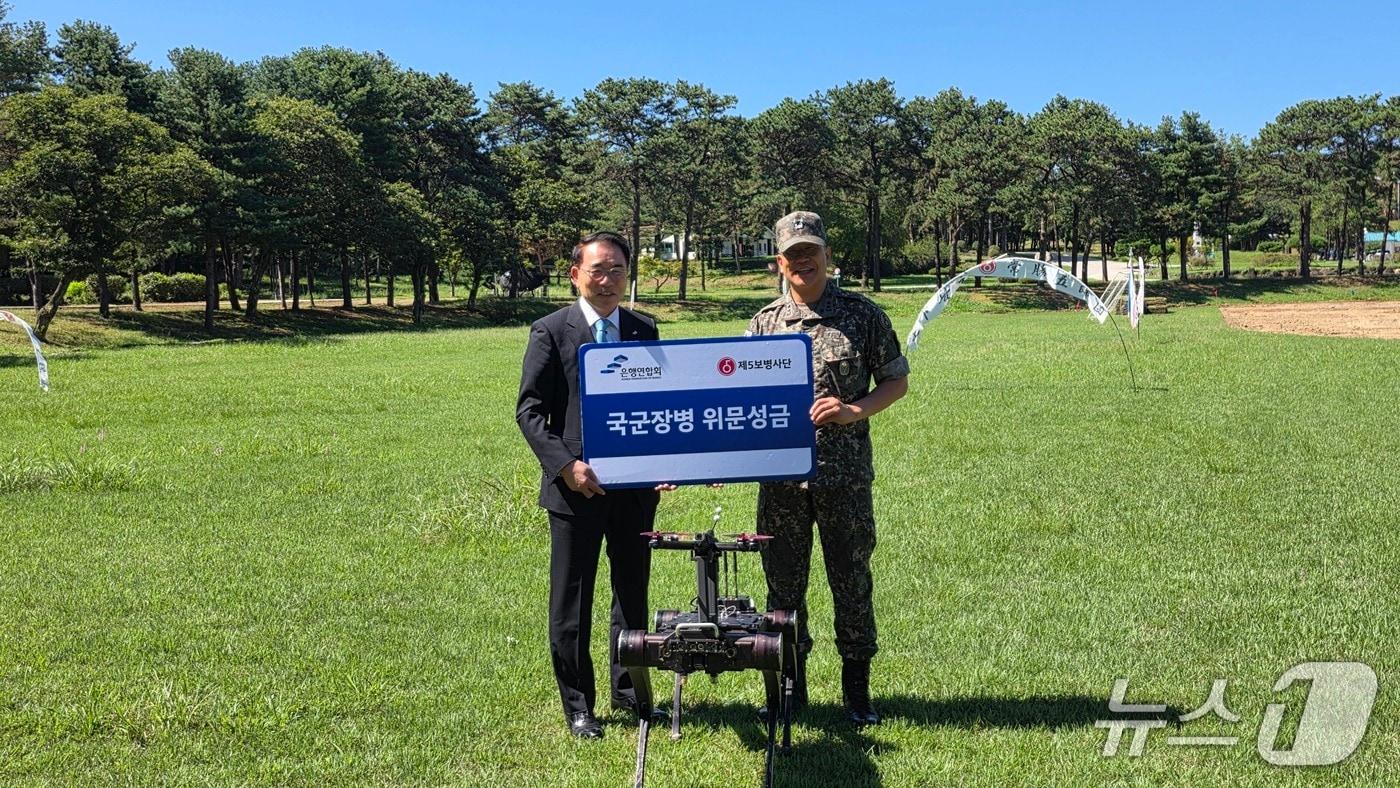 본문 이미지 - 위문금 전달식 주요 참석자들이 기념촬영을 하고 있는 모습 (좌) 조용병 은행연합회 회장, (우) 육군 제5보병사단 이종현 소장. 2026.09.04 / 사진제공=은행연합회