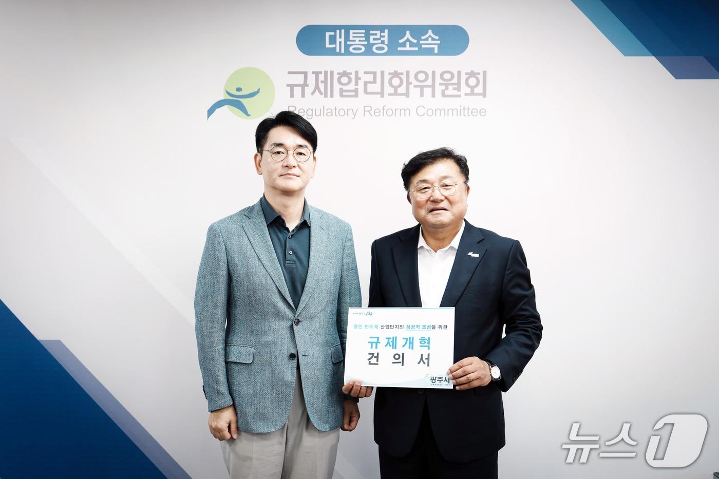 본문 이미지 - 박관열 시장(오른쪽)이 박용진 규제합리화위원회 부위원장에게 규제개혁 건의서를 전달하고 있는 모습.(광주시 제공)