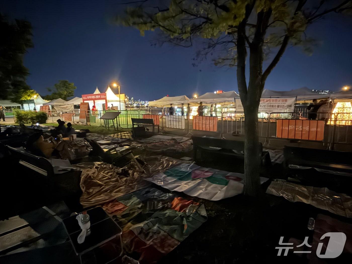 본문 이미지 - 5일 오후 8시 30분 '서울세계불꽃축제 2026' 전야제가 진행된 서울 영등포구 여의도 한강공원. 전야제를 알리는 소규모 불꽃놀이가 진행된 뒤에도 정리되지 않은 돗자리들이 깔렸다./뉴스1 ⓒ News1 한수민 수습기자