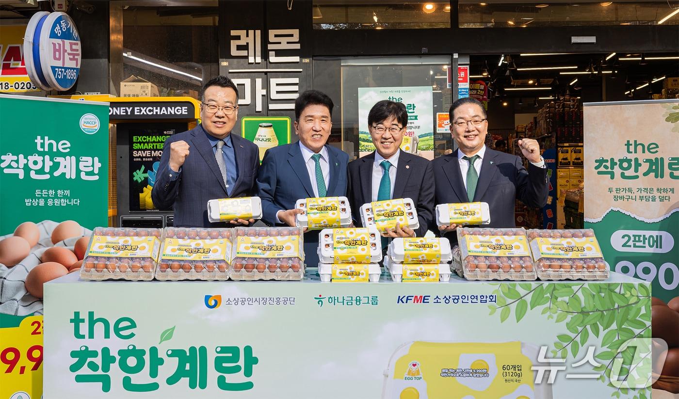 본문 이미지 - 하나금융그룹은 지난 4일 하나금융그룹 명동사옥에서 소상공인시장진흥공단·소상공인연합회와 함께 동네슈퍼 착한계란 공급 통한 물가안정화 지원' 업무협약을 체결했다. 협약식 직후 참석자들이 명동사옥 인근 동네슈퍼를 직접 방문해 the착한계란 상품과 판매 준비 상황을 살펴보고 기념촬영을 하고 있다.  (사진 왼쪽부터 권혁환 소상공인연합회 부회장, 함영주 하나금융그룹 회장, 인태연 소상공인시장진흥공단 이사장, 이호성 하나은행장 순) 2026.09.04 / 사진제공=하나금융