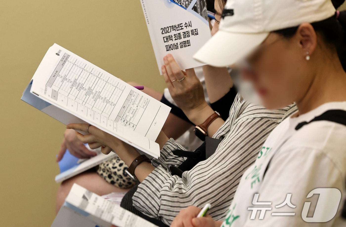 본문 이미지 - 6일 서울 강남구 강남종로학원 대강당에서 열린 종로학원 9월 모의평가 긴급분석 및 2027 수시대학 최종 결정 파이널 설명회를 찾은 학부모들이 자료를 살펴보고 있다. 2027학년도 입시는 내신 9등급제와 통합 대학수학능력시험(수능)으로 치러지는 마지막 해로 오는 7일부터 대학입학 수시모집 원서접수가 시작된다. 2026.9.6 ⓒ 뉴스1 김진환 기자
