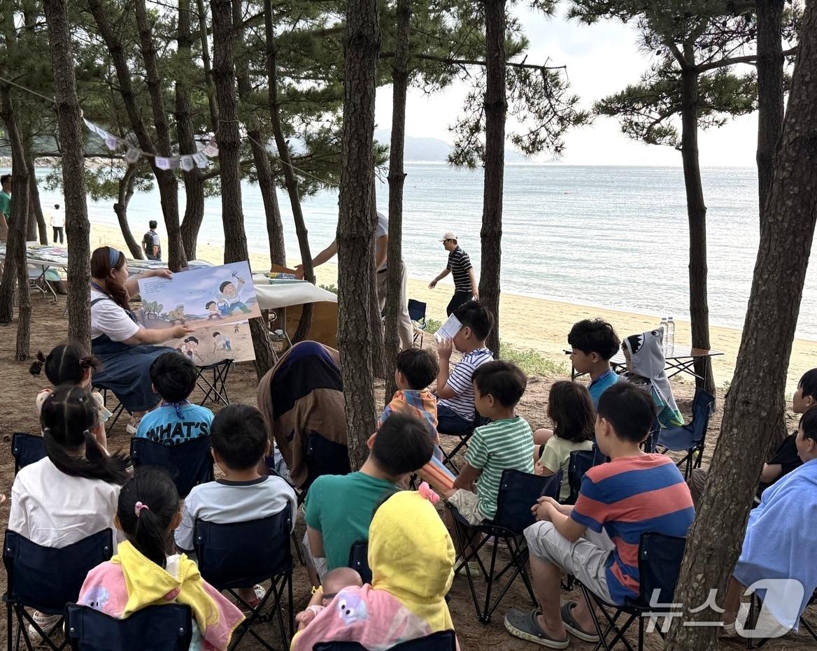 본문 이미지 - 지난 8월 22일부터 23일까지 인천 옹진군 덕적도에서 열린 ‘북(Book)적도’ 행사에서 교사가 참여한 어린이들에게 그림책을 읽어주고 있다. (대교 제공. 재판매 및 DB금지)