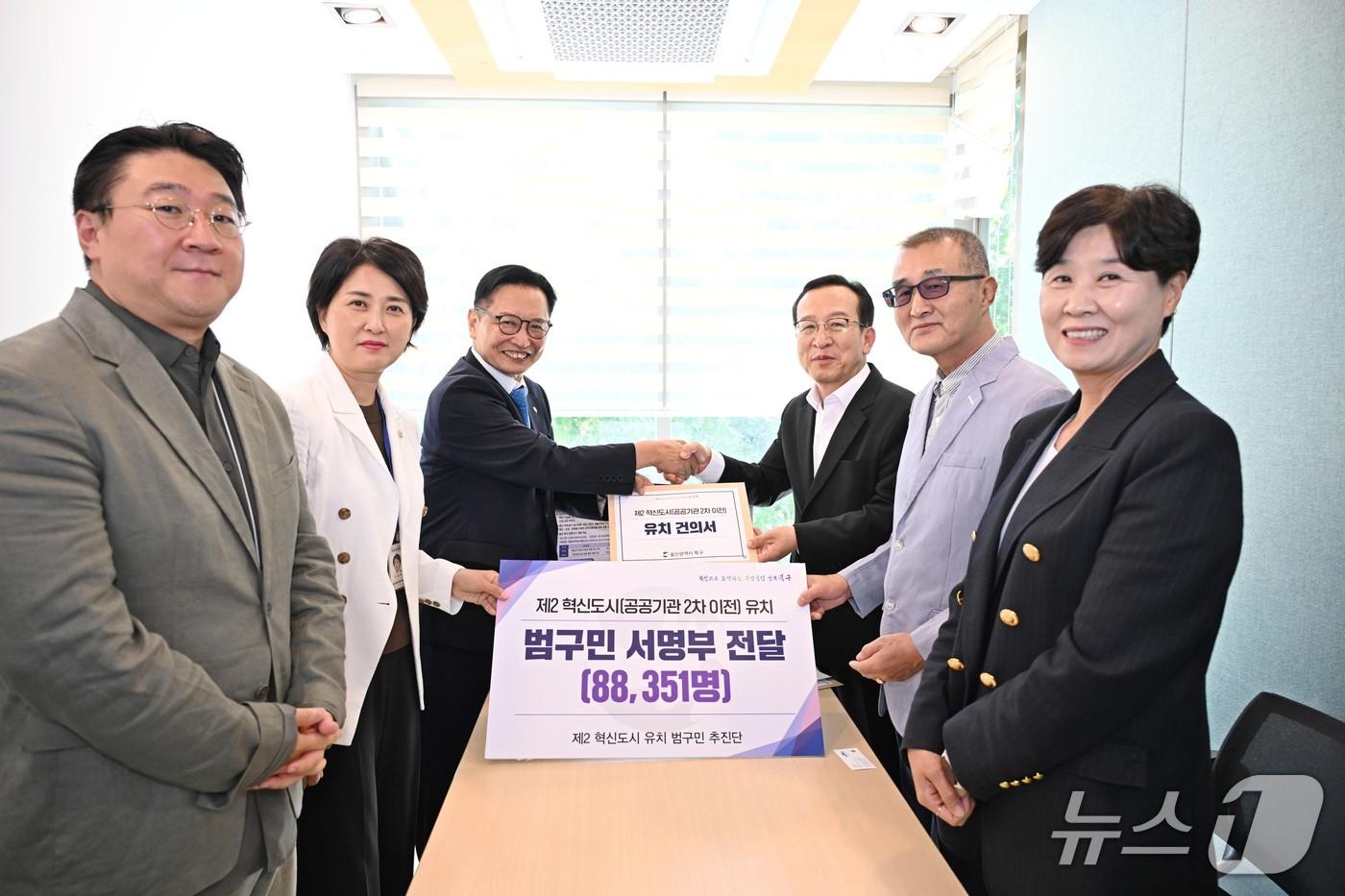 본문 이미지 - 이동권 북구청장(왼쪽에서 세번째)이 7일 청와대를 방문해 김태근 자치발전비서관(오른쪽 세번째)에게 공공기관 2차 이전 유치 건의서와 범구민 서명부를 전달했다.2026.09.07.(울산 북구 제공. 재판매 및 DB금지)/뉴스1