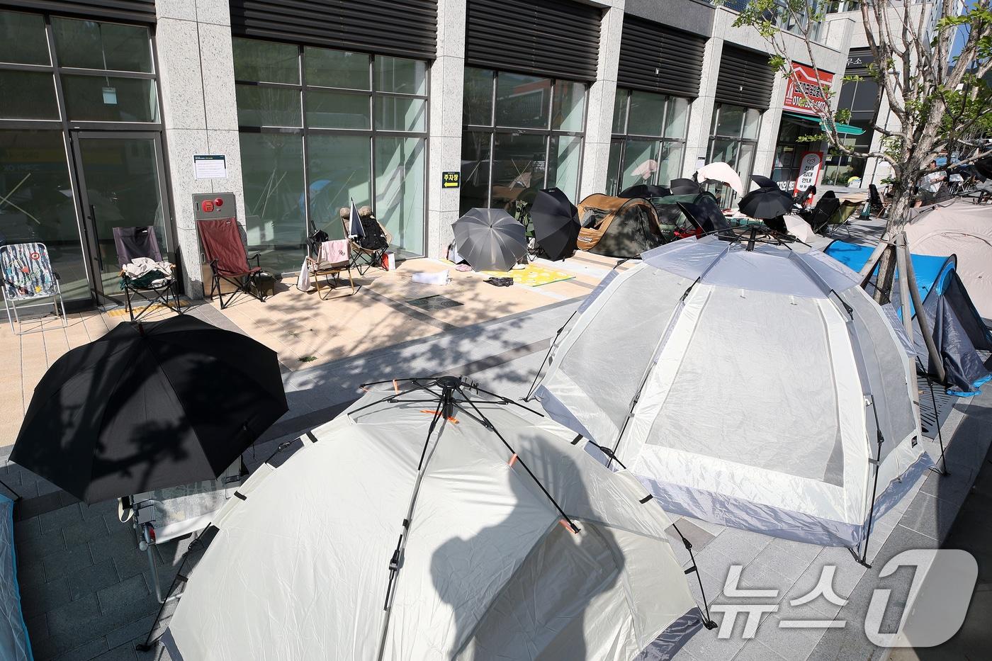 본문 이미지 - 지난 7일 오후 대구 달서구 '상인 푸르지오 센터파크' 분양사무소 앞에 선착순 전세 계약 접수를 기다리는 사람들이 우산, 텐트, 그늘막, 캠핑용 의자 등으로 자리를 맡은 채 장사진을 이루고 있다. 2026.9.7 ⓒ 뉴스1 공정식 기자