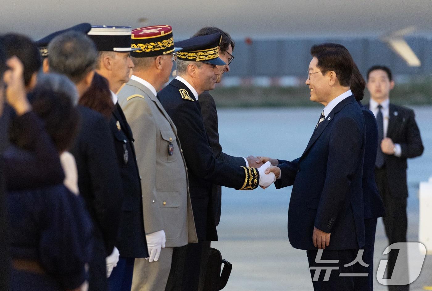 본문 이미지 - 프랑스를 국빈 방문 중인 이재명 대통령과 김혜경 여사가 7일(현지시간) 파리 오를리 국제공항에서 환영객과 인사하고 있다. 2026.9.8 ⓒ 뉴스1 이재명 기자