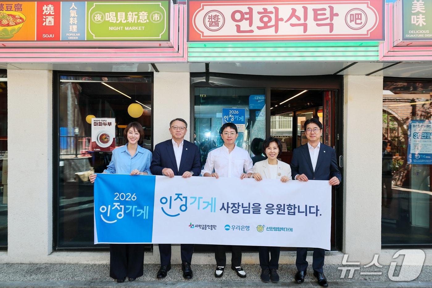 본문 이미지 - 지난 7일 서울 마포구 소재 연화식탁에서 열린 '인정가게' 현판식에서 (왼쪽부터) 선한영향력가게 김성령 의장, 우리은행 정진완 은행장, 연화식탁 홍성운 대표, 서민금융진흥원 김은경 원장, 우리은행 성시천 경영기획그룹장이 기념사진을 촬영하고 있다.2026.09.07 / 사진제공=우리은행