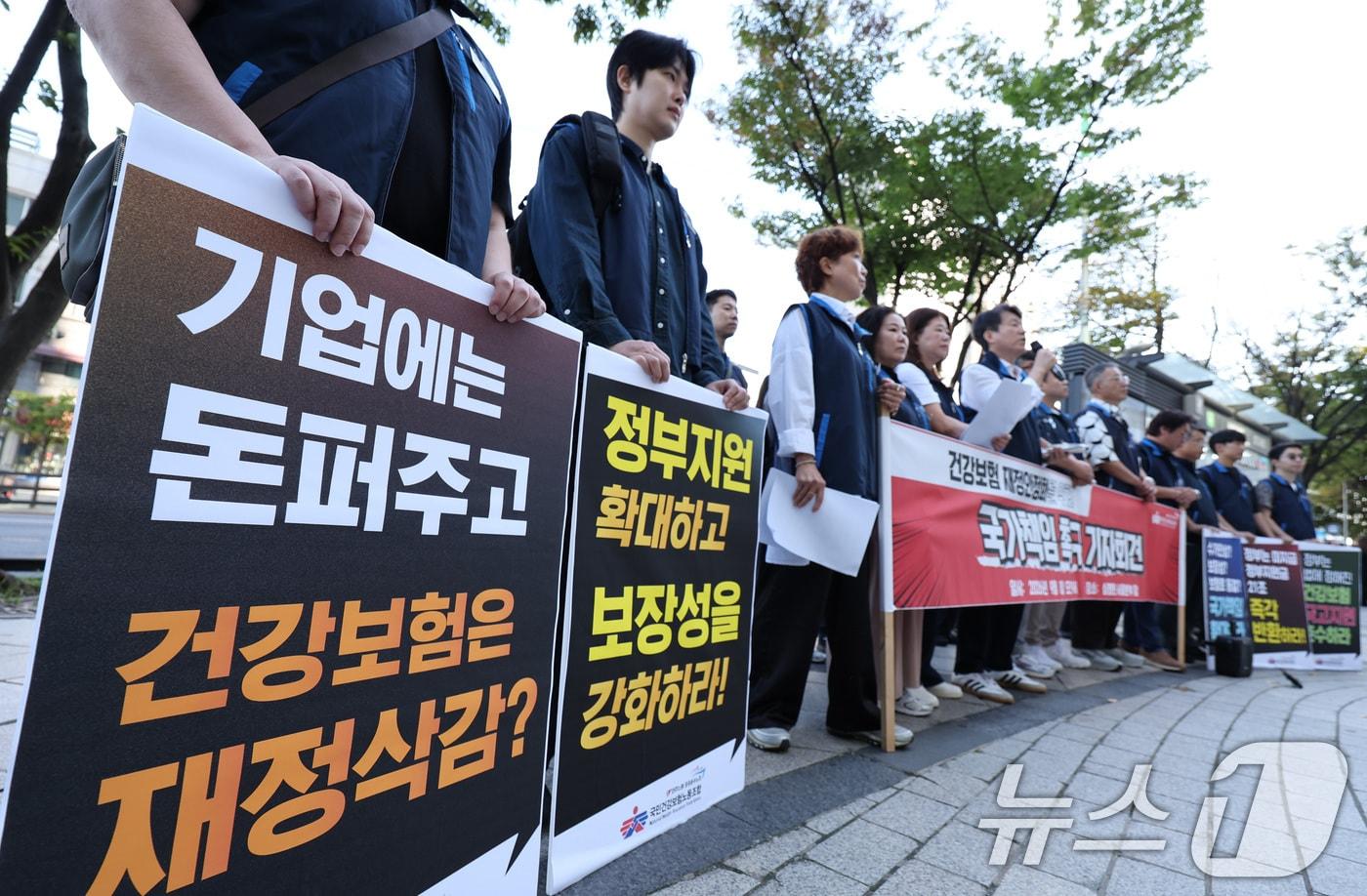 본문 이미지 - 민주노총 공공운수노조 국민건강보험노동조합 조합원들이 8일 서울 서초구 건강보험심사평가원 앞에서 열린 '건강보험 재정안정화를 위한 국가책임 촉구 기자회견'에서 정부 지원 확대와 보장성 강화를 촉구하고 있다. 2026.9.8 ⓒ 뉴스1 박지혜 기자
