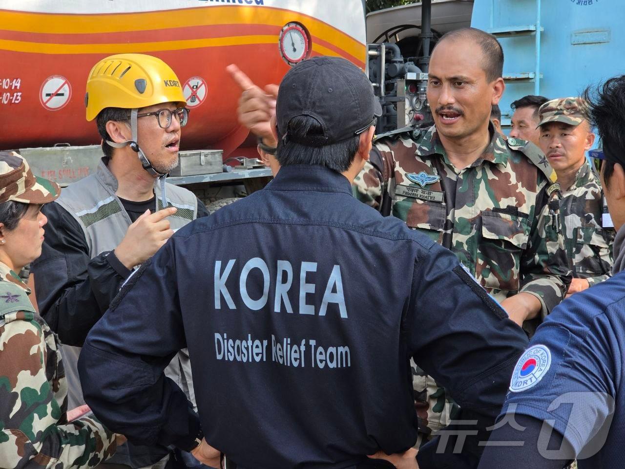 본문 이미지 - 한국해외긴급구호대(KDRT) 대원들이 8일(현지시간) 네팔 바그마티주 누와코트 바타르 네팔 군기지에서 헬기 착륙 지점을 바타르 지역 군인들과 논의하고 있다. (한국해외긴급구호대 제공. 재판매 및 DB 금지) 2026.9.8 ⓒ 뉴스1