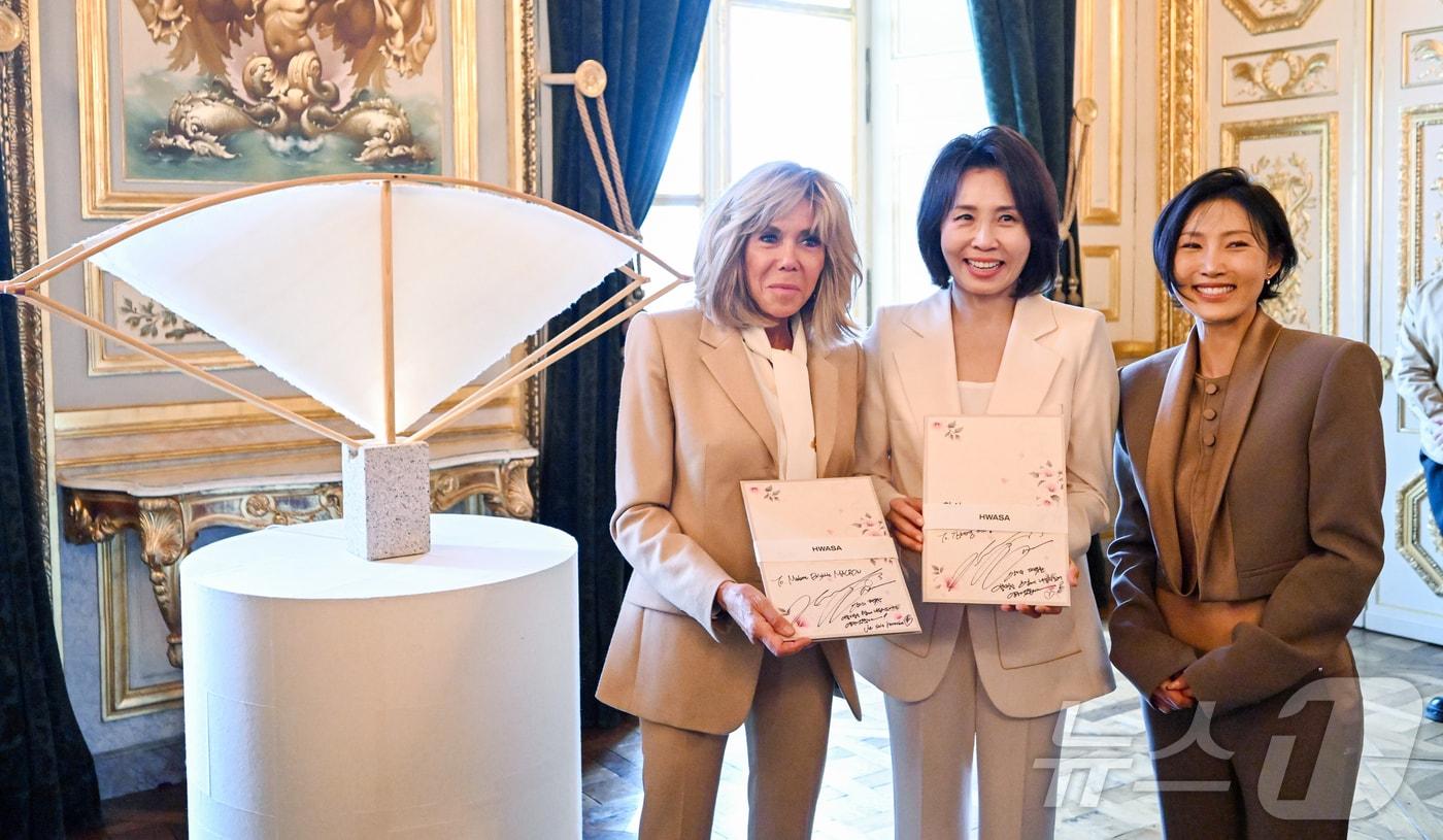 본문 이미지 - 김혜경 여사와 프랑스 대통령 부인 브리지트 마크롱 여사가 8일(현지시간) 파리 오텔 드 라 마린에서 열린 한지마니아 특별전에서 가수 화사와 한지 케이스 앨범을 들고 기념촬영을 하고 있다. 2026.9.9 ⓒ 뉴스1 이재명 기자