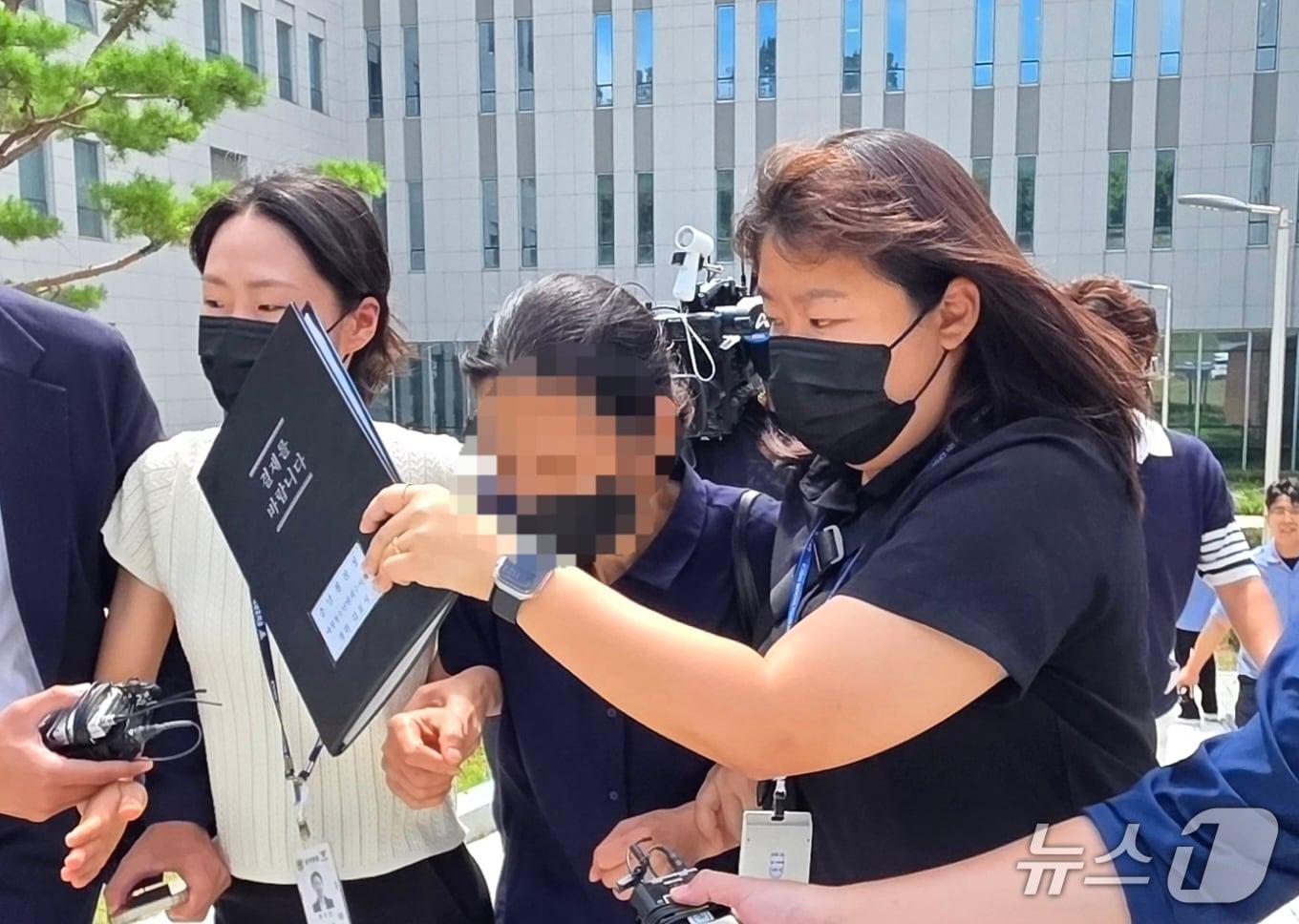본문 이미지 - 장애가 있는 외손자를 학대해 숨지게 한 혐의를 받고 있는 외조모 A 씨(55)가 영장실질심사를 마치고 법원을 빠져나가고 있다. /뉴스1