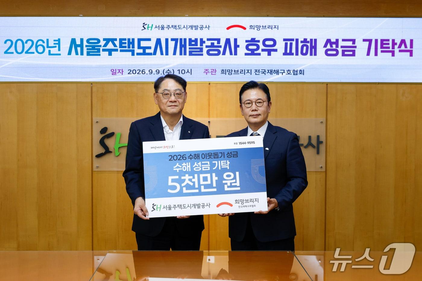 본문 이미지 - 황상하 서울주택도시개발공사(SH) 사장(왼쪽)과 신훈 희망브리지 사무총장이 9일 SH에서 열린 집중호우 피해지역 복구 성금 기탁식에서 기념촬영을 하고 있다. (SH 제공)