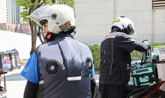 폭염 속 선풍기 자켓 입은 이동노동자