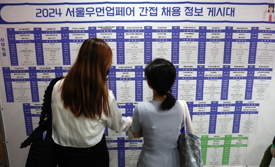 채용 정보 게시대 바라보는 여성구직자들