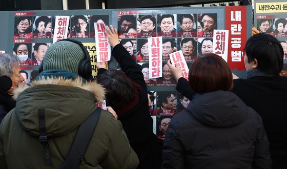 국민의힘 의원들 얼굴에 해체 스티커 붙이는 시민단체