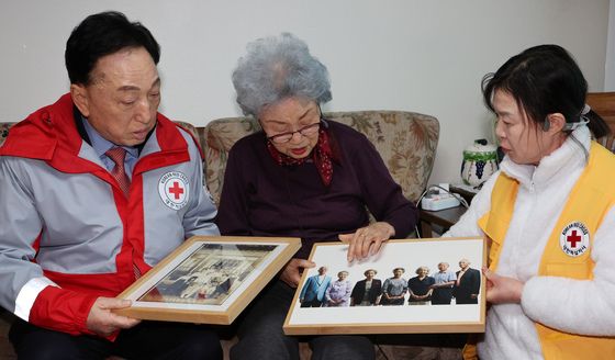 옛 가족사진과 AI로 합성된 이산가족 사진 바라보는 임화숙 어르신