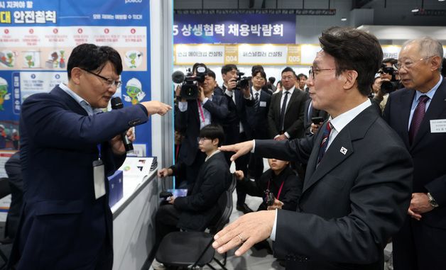 부스 둘러보며 대화하는 김민석 총리