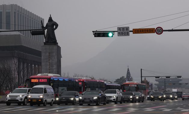 뿌연 도심에 전조등 켠 차량들