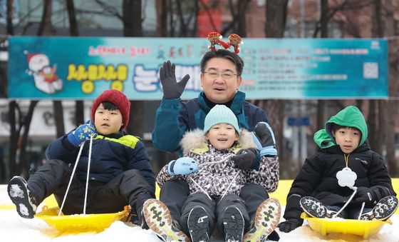 어린이들과 눈썰매 타는 오승록 구청장