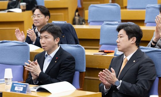 나란히 앉아 박수 치는 유승민 회장과 진종오 의원