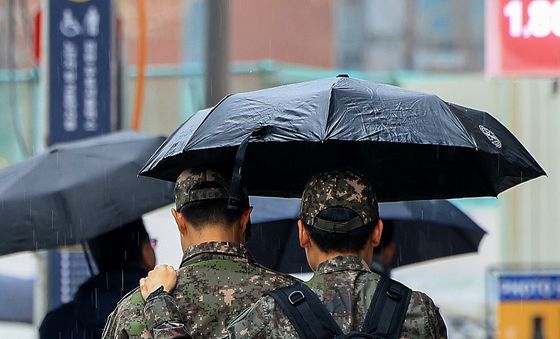 우산 함께 쓴 군인들