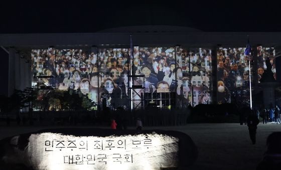 국회 외벽에 나오는 촛불 시민들 모습