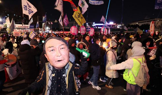 '계엄 1년' 윤석열 가면 쓰고 국회 앞 행진하는 시민